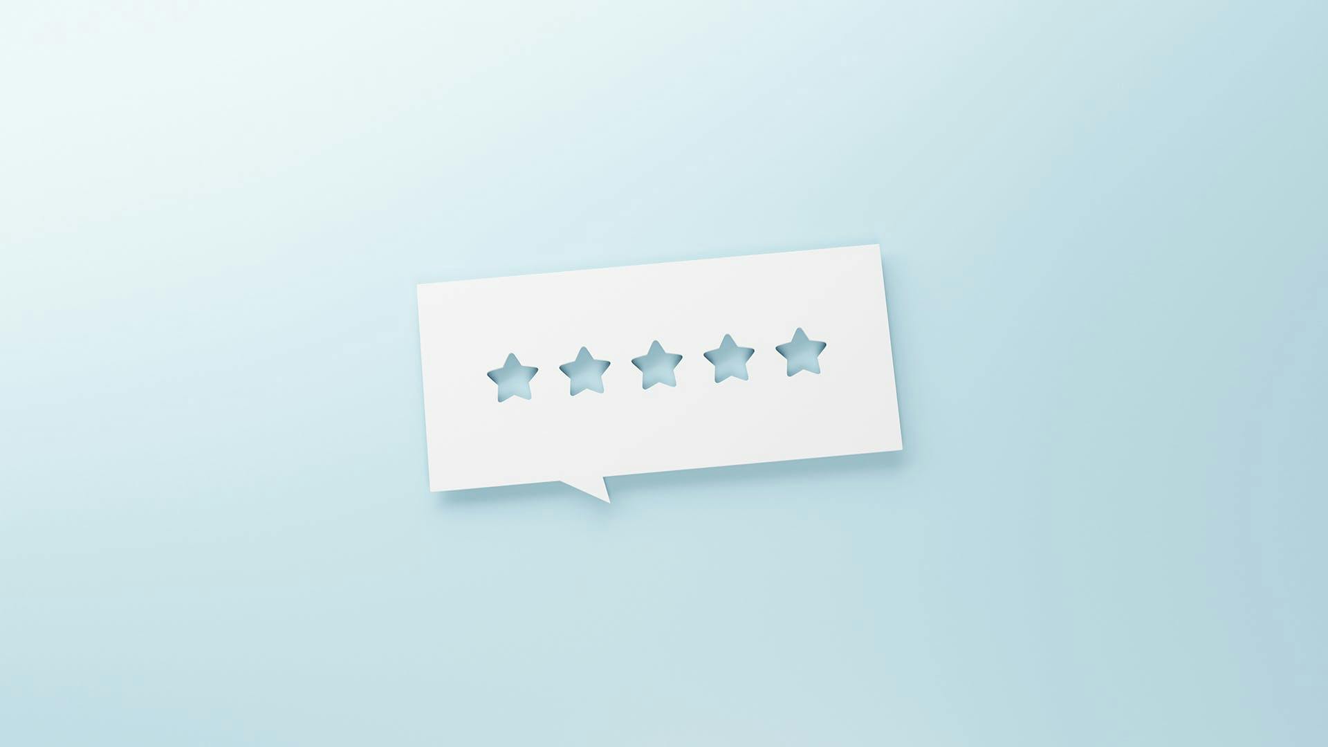 An image of a white chat bubble with five stars in the center. The stars are cut out of the paper chat bubble so that you can see the blue background underneath. The image represents an online review that marketing teams may find or manage using an online reputation management software.