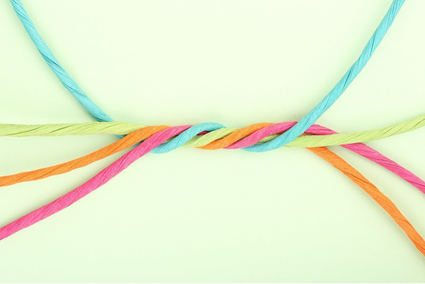 Blue, green, orange, and pink strings twisting around each other.