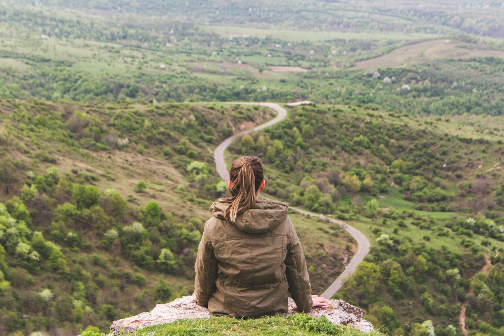 Young woman looking out over winding road. Understanding your customer journey is crucial to successful marketing strategy.