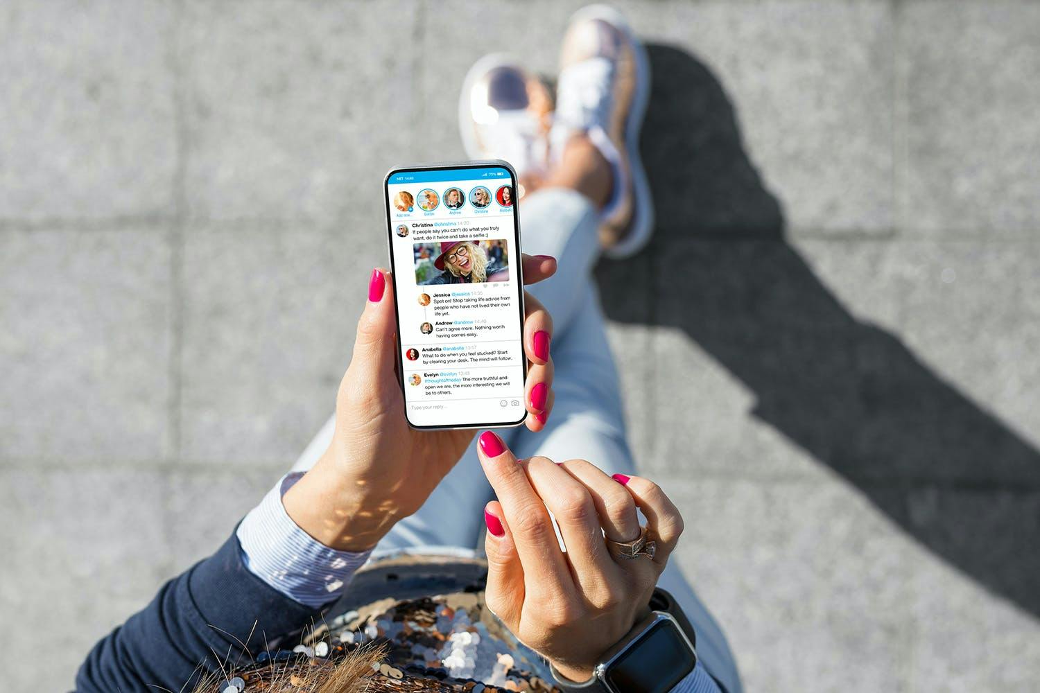 Image of a person walking down the street with a smartphone with an open Twitter screen in her hand and feet.