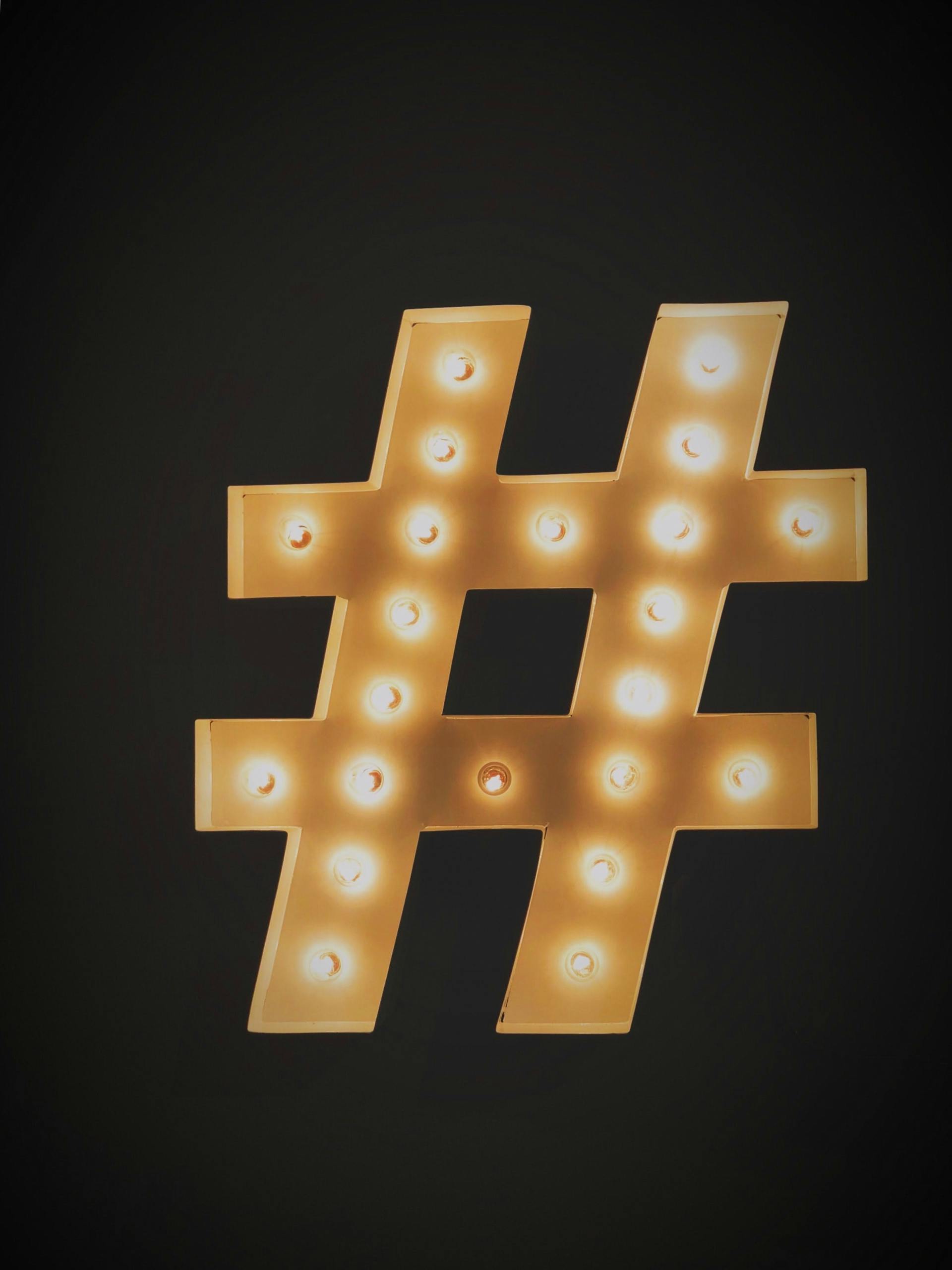 Le symbole du hashtag s'éclaire sur un fond noir. Couramment utilisé dans le marketing stratégique des réseaux sociaux.