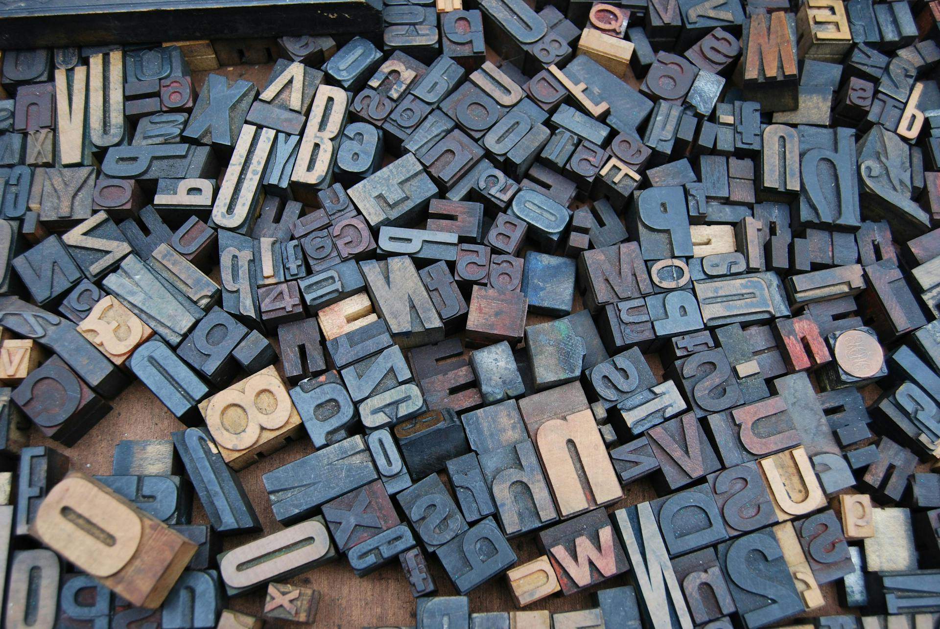 Jumble of letter and number stamps in a pile. Proper spelling and grammar is important for social media posting