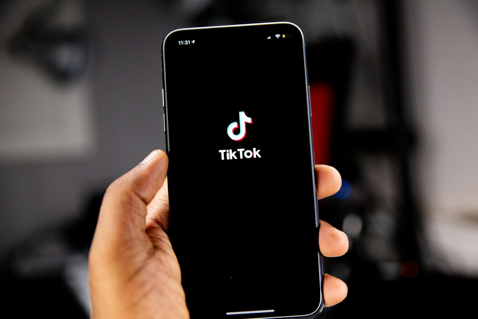 Person holding phone showing TikTok logo