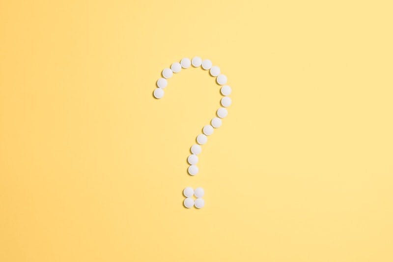 A white question mark on a yellow background