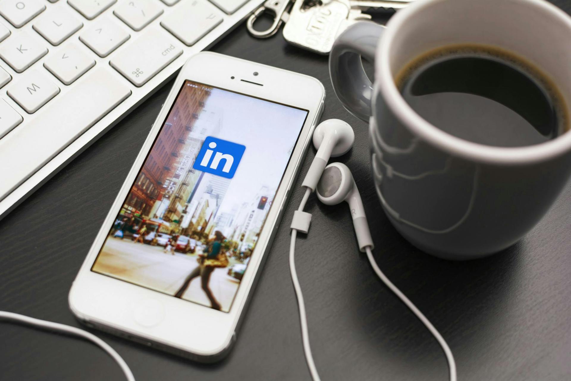 LinkedIn auf Smartphone neben Kaffeetasse