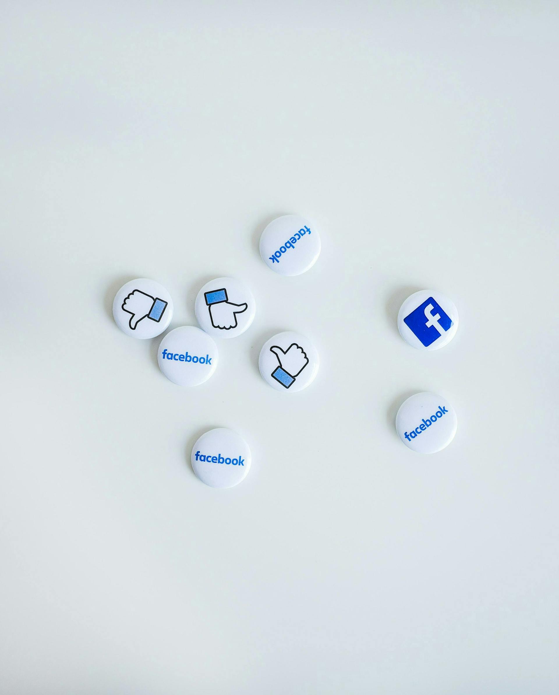 facebook logo and like button on white thumbnails on a white table