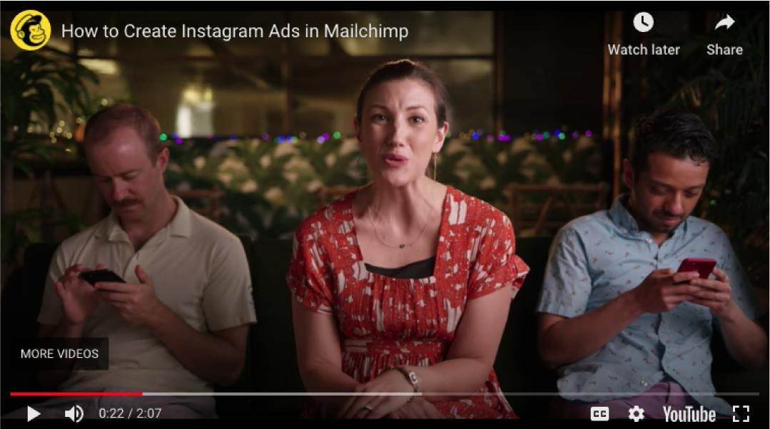 Vidéo MailChimp : une femme en rouge au milieu de deux hommes sur leurs téléphones, expliquant comment créer des publicités Instagram sur MailChimp