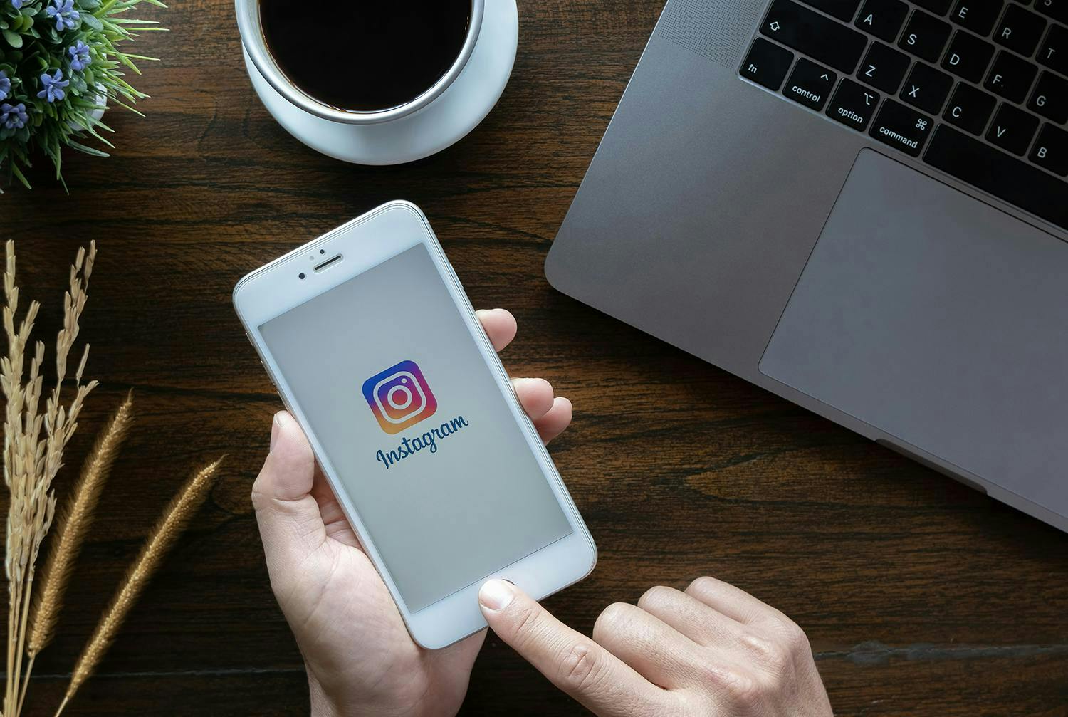 Image of the hand holding the smartphone with the Instagram logo displayed.