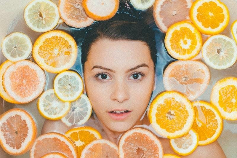 A woman surrounded by sliced lemons and oranges