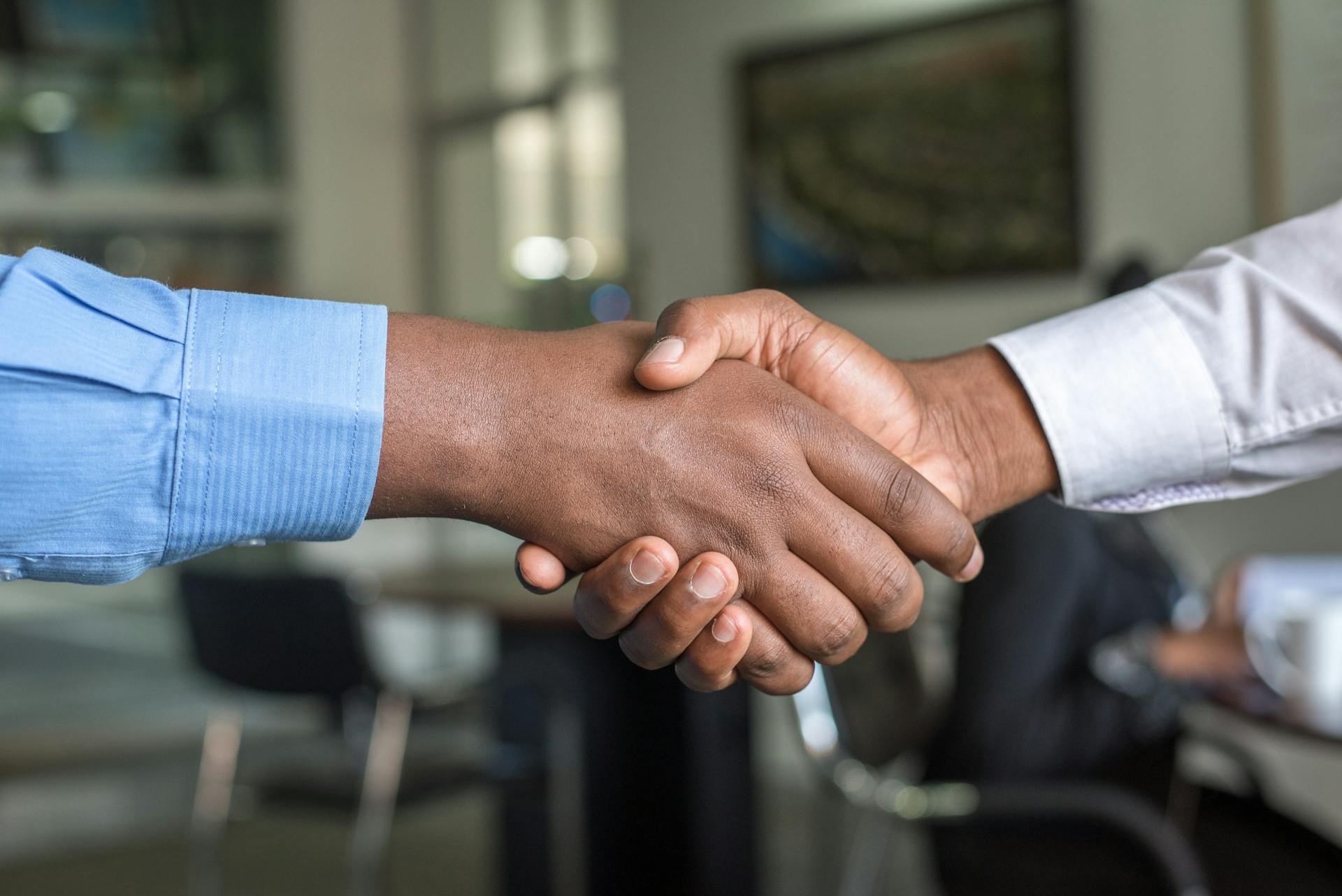 Two men shaking hands in a stock photo. Try to avoid cliches when blogging