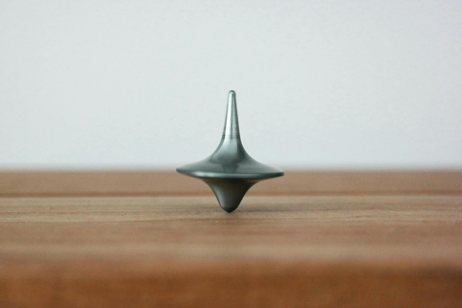 Childs spinning top toy balancing on a table. Looking at past metrics is important for writing a communication plan