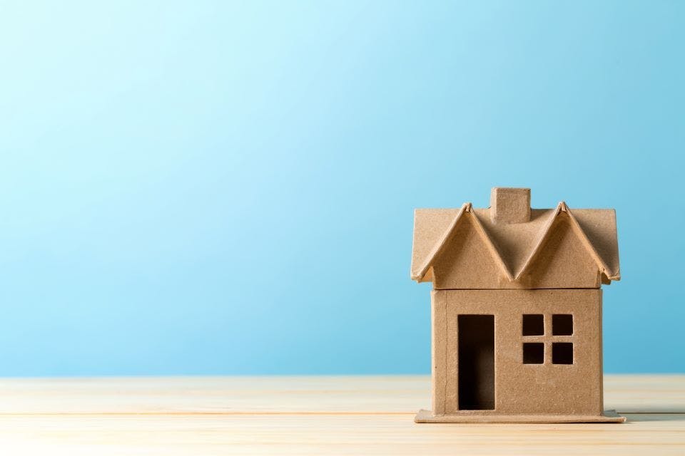 Image of a cardboard house with blue background