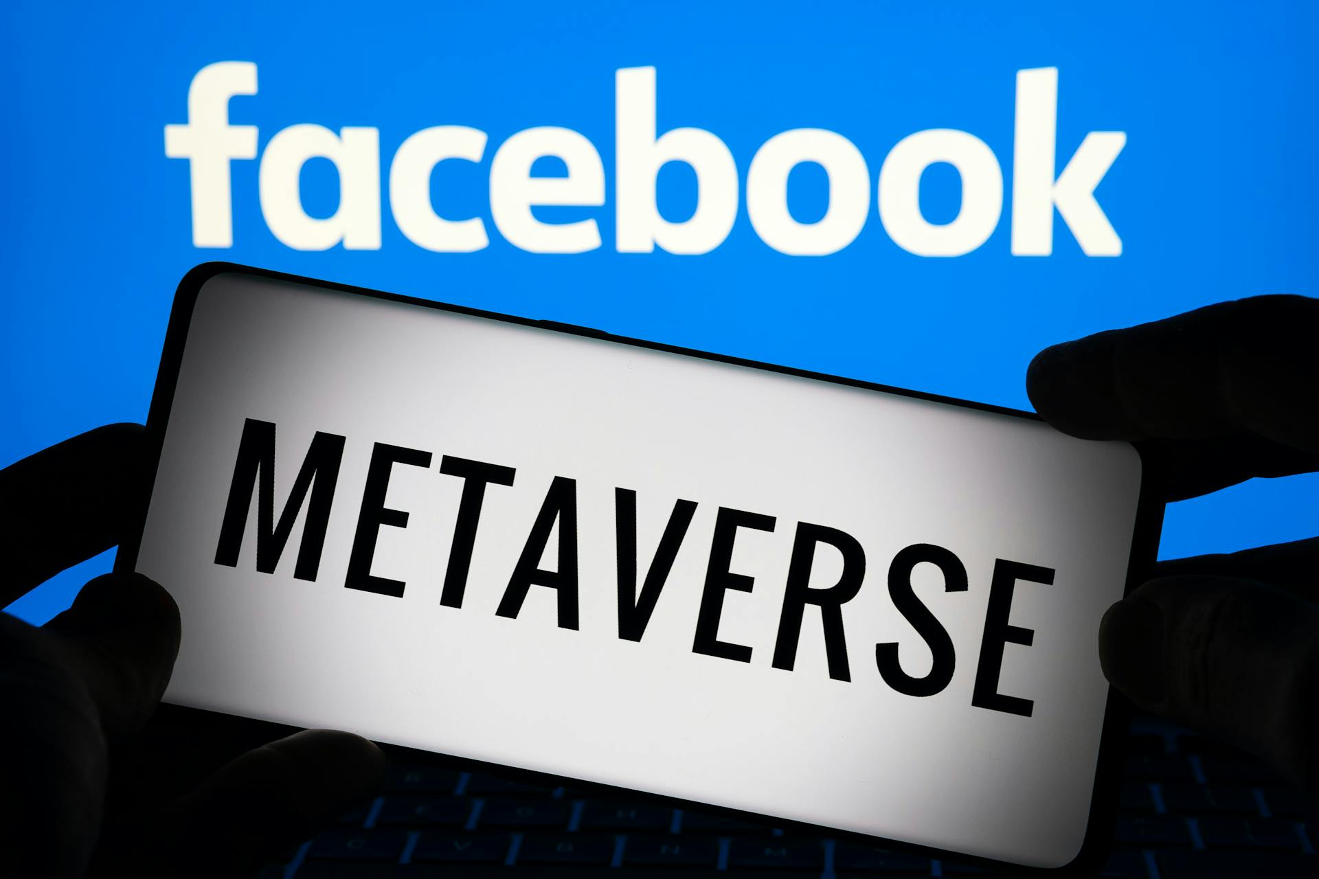 Logo de Facebook avec quelqu'un qui tient le mot métaverse.