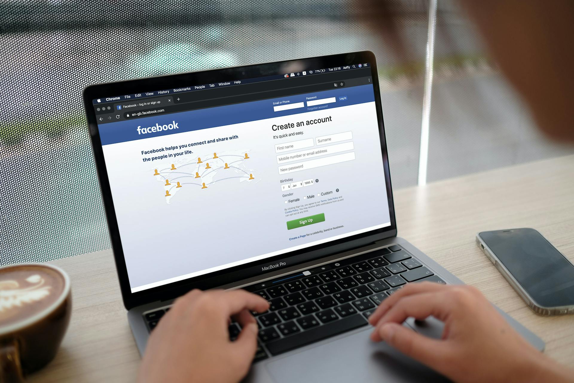 Image of a laptop on a desk with a facebook login image displayed.