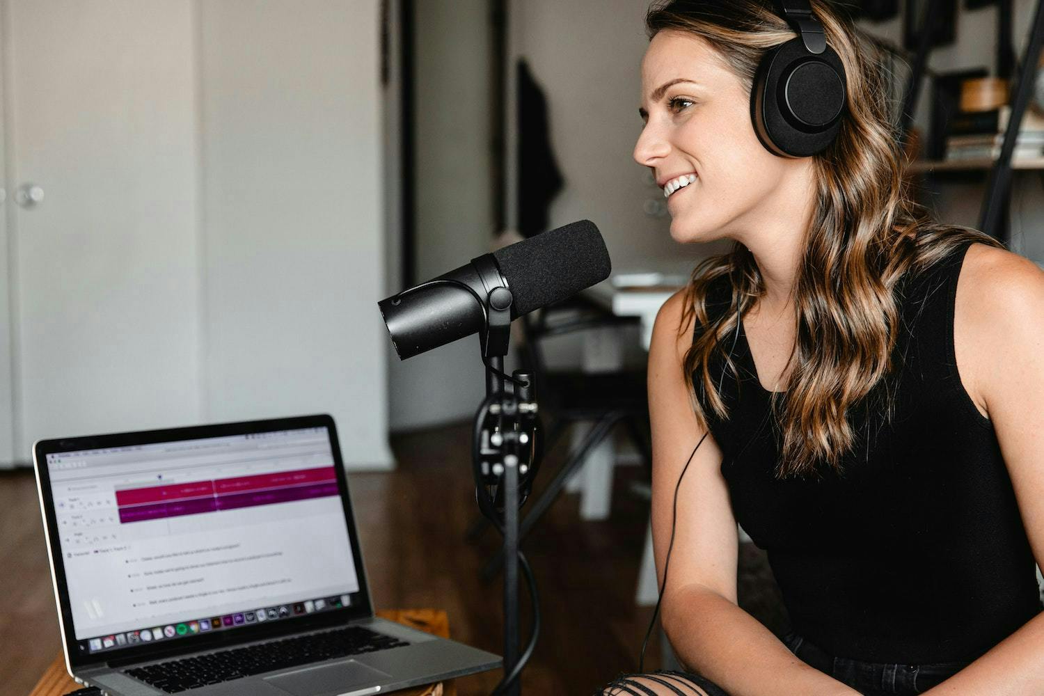 Young woman with headphones and a microphone running a livestream for a brand
