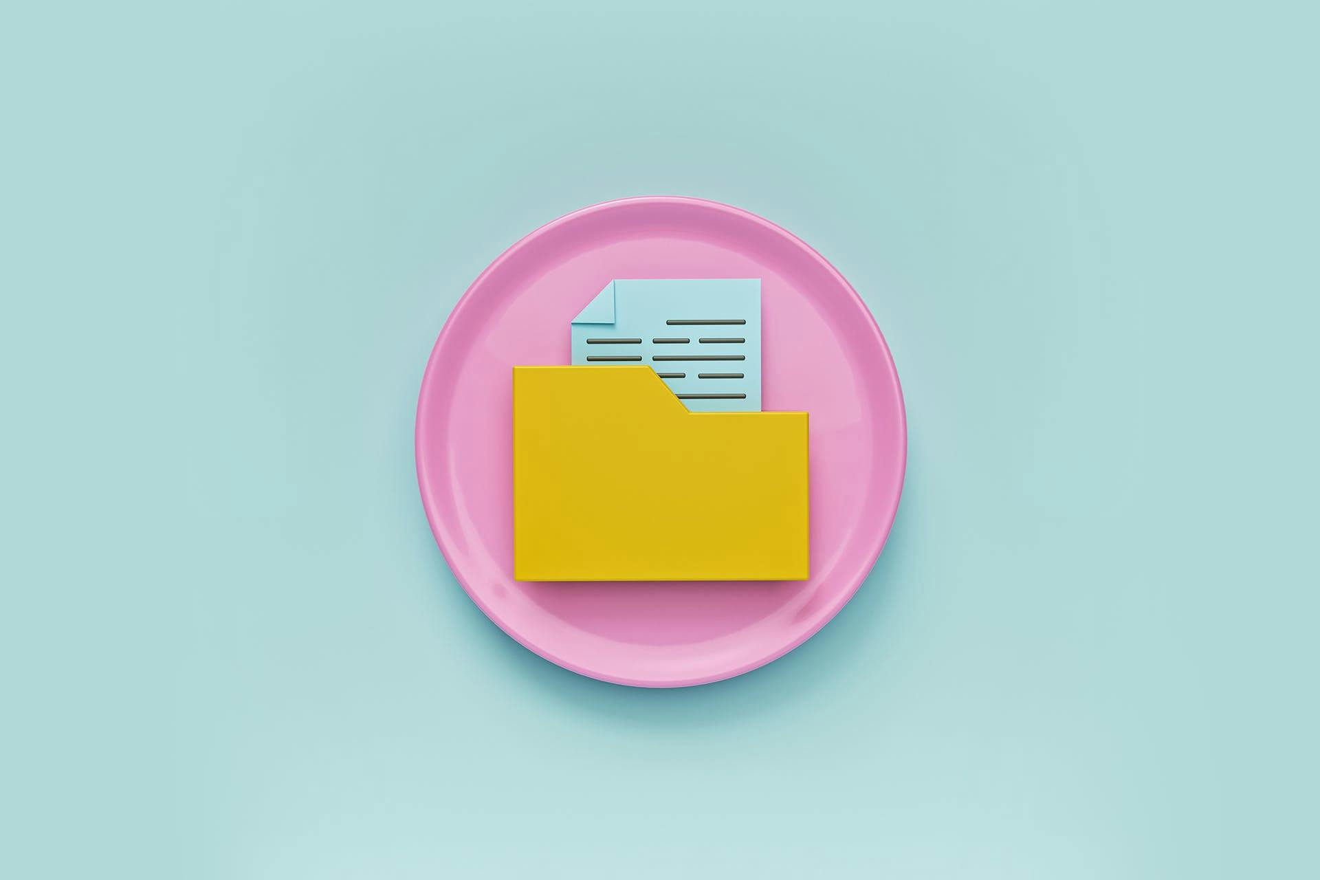 un rond rose dans lequel est disposé un dossier jaune contenant un fichier