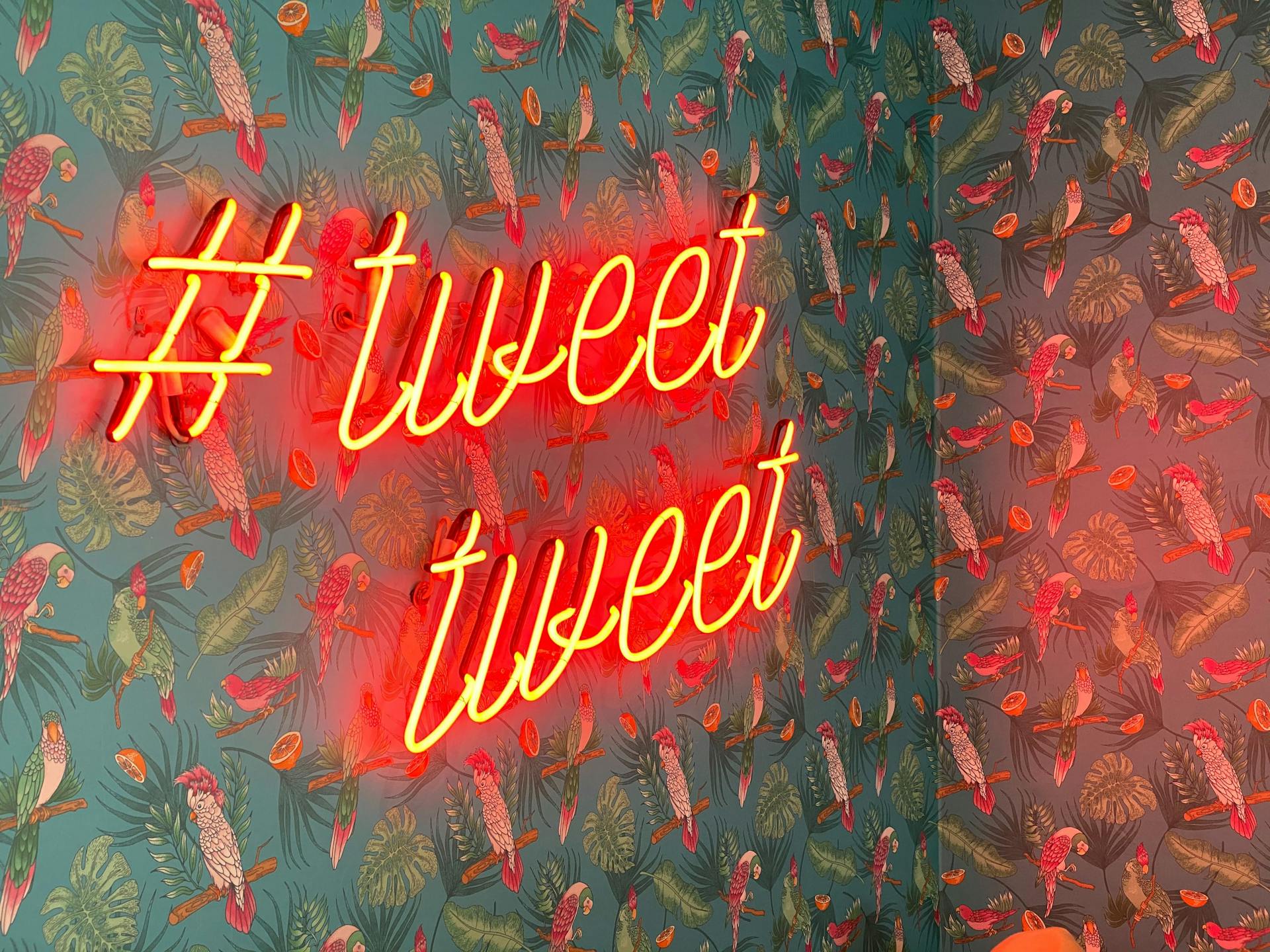 Neon sign with hashtag and two words saying Tweet
