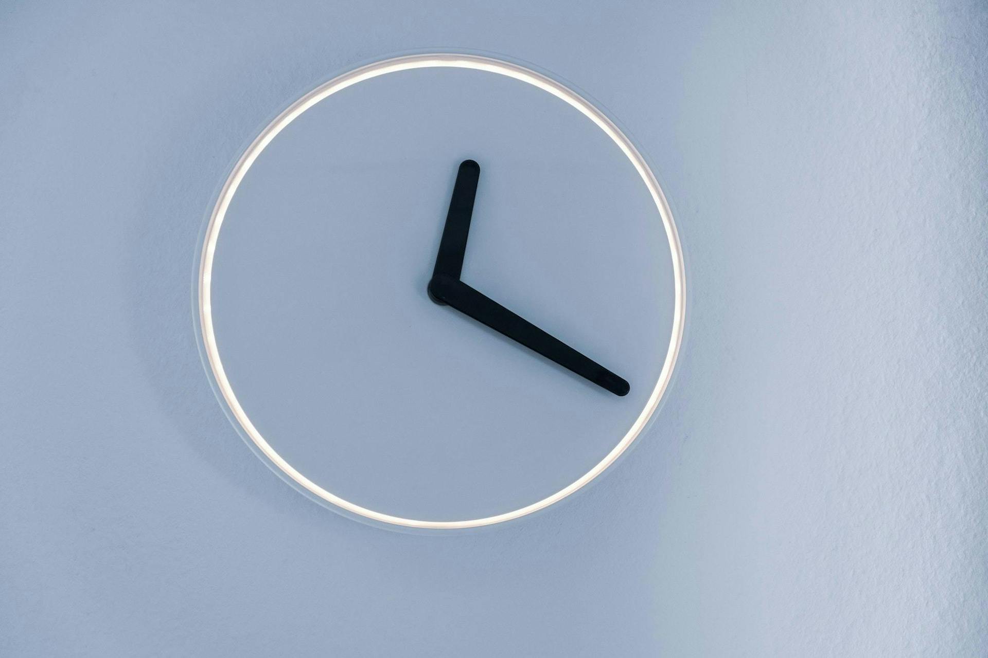 Image of a minimalistic clock with hands indicating the time 1:20.