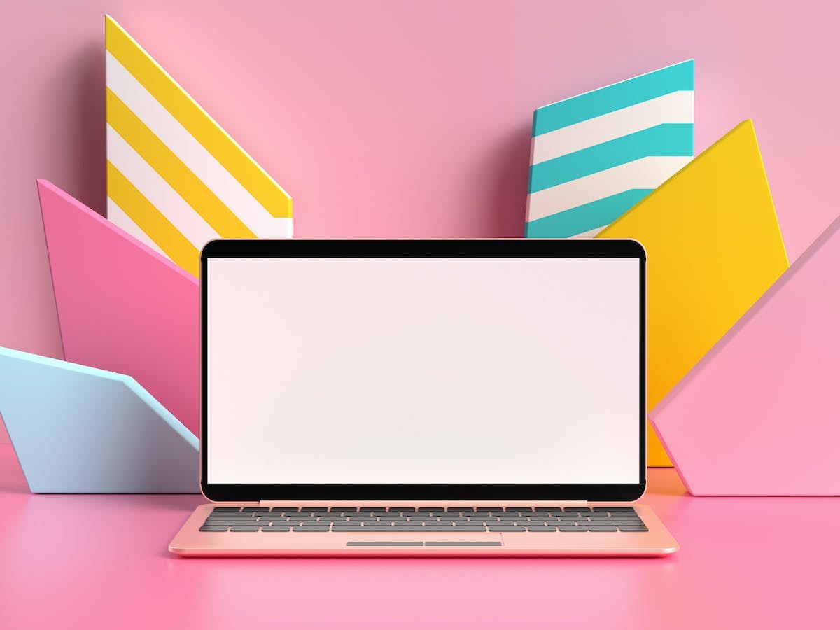 Image of a laptop in front of a pink and colorful background