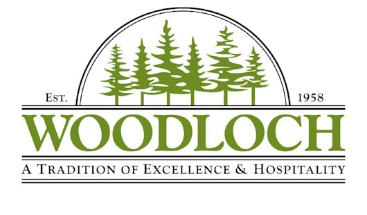 The logo of Woodloch Resort, which features six green pine trees and the words "Est. 1958, Woodloch, A Tradition of Excellence & Hospitality".