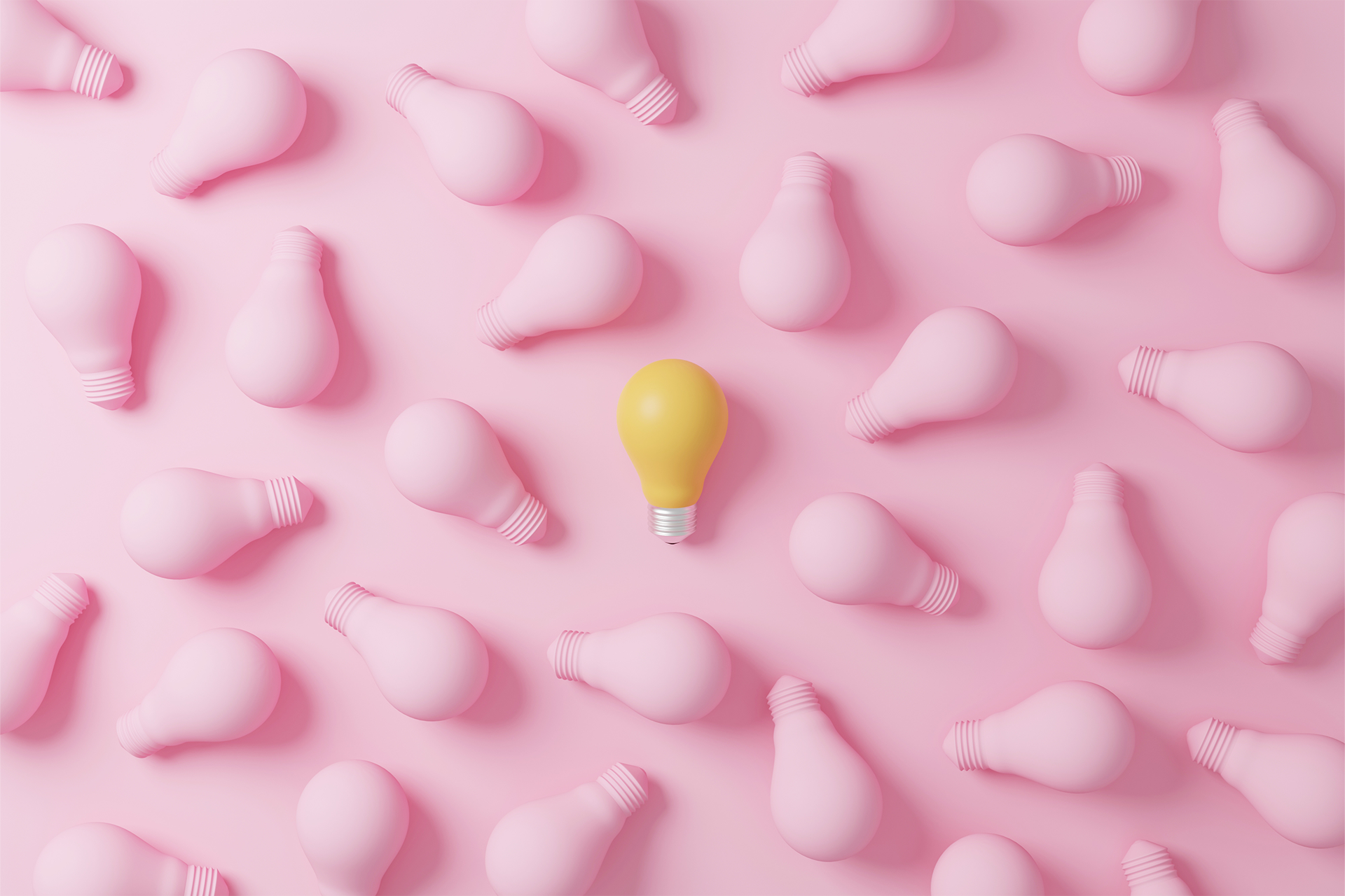 Yellow lightbulb in the middle of several pink lightbulbs