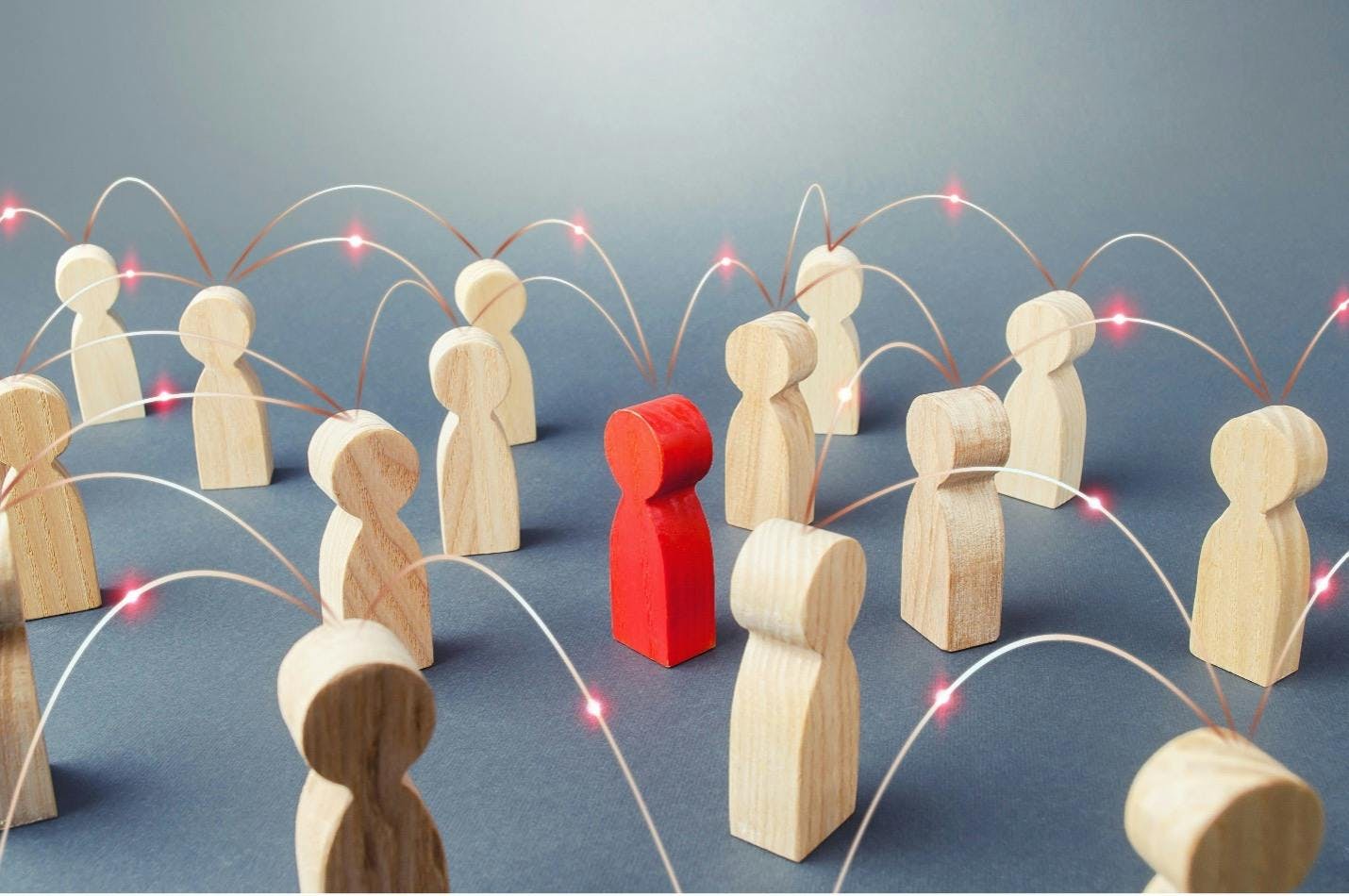 A red wooden figure connects with plain wooden figures in this image for a blog about user-generated content.